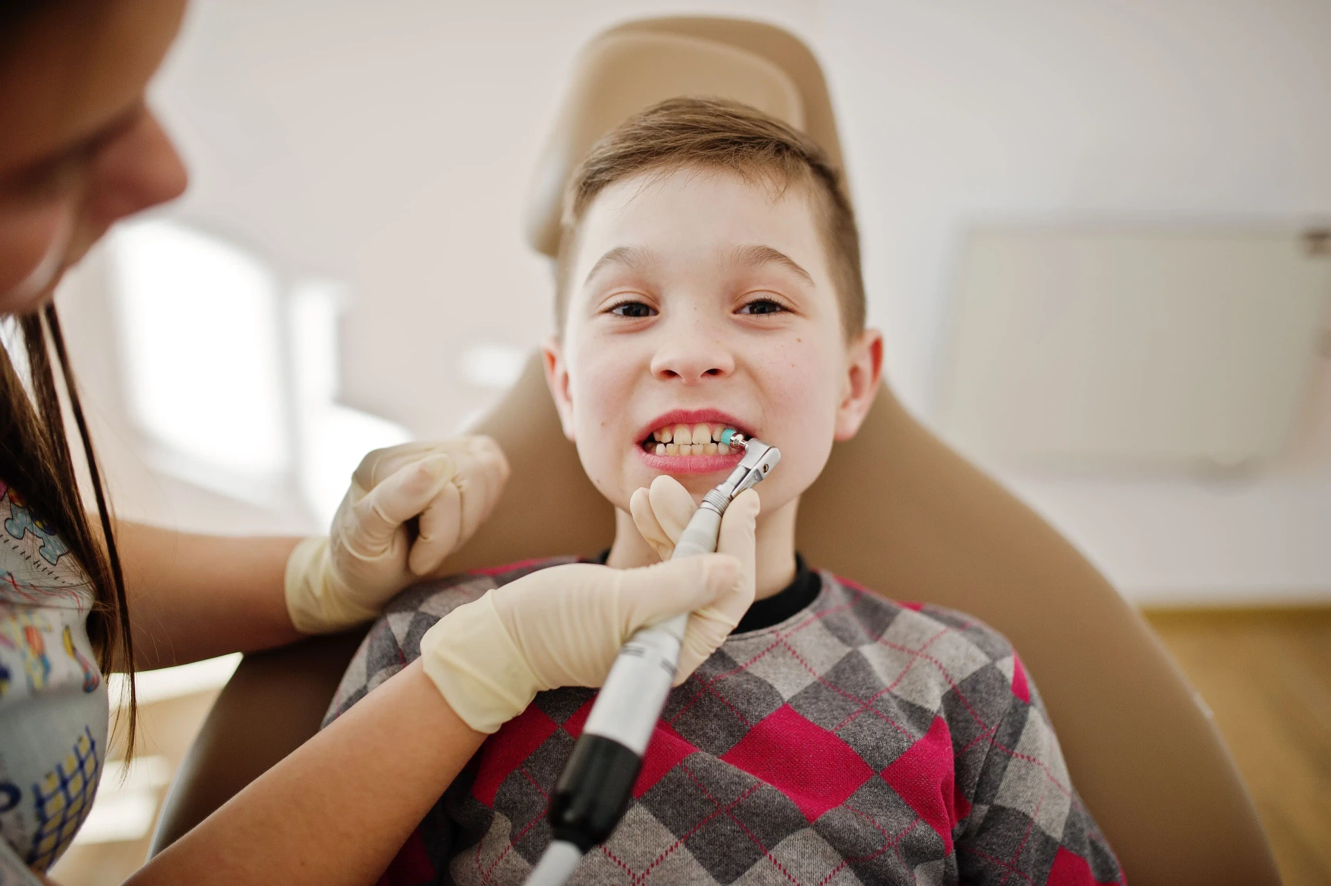 Child receiving restorative dental treatment for a stainless steel crown